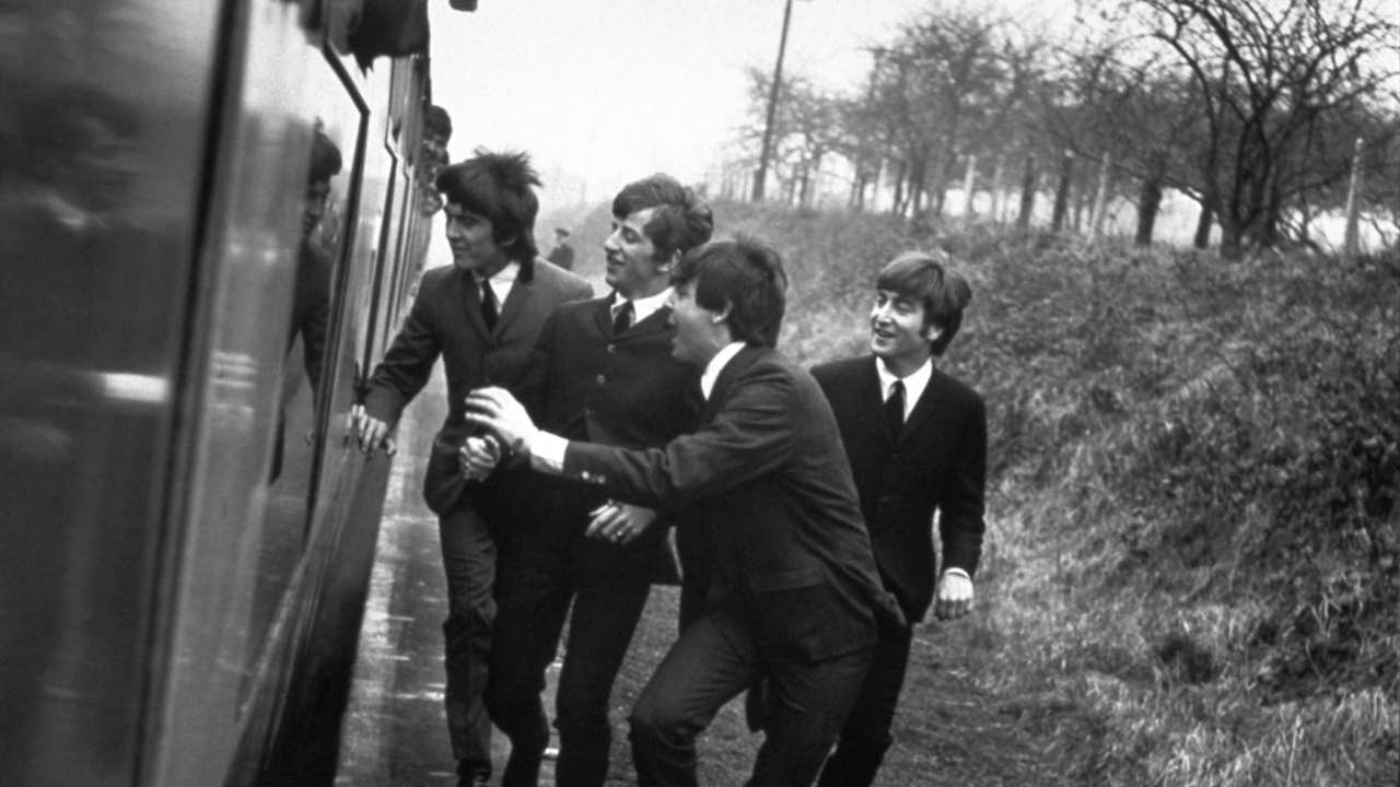 The Beatles running alongside a train